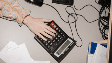 Une main en train de taper à la calculatrice
