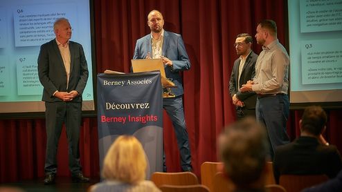 4 collaborateurs présentant devant un public Berney Insights, un outil de Business Intelligence